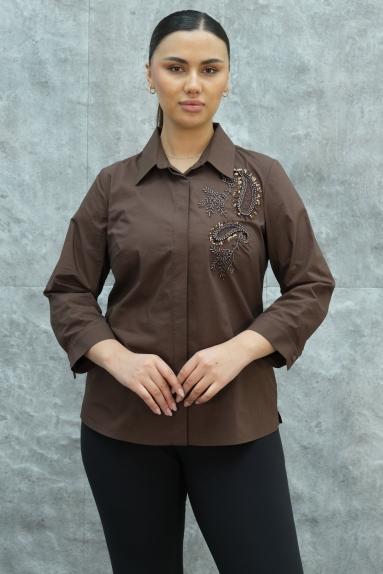  This plus size womens shirt stands out with its brown color. The shirt is available in sizes 42, 44, 46, and 48. The fabric composition is 65% cotton, 30% polyester, and 5% elastane, providing comfortable stretch and longevity to the product. The front of the shirt features elegant embroidery details. With its wide collar and long sleeves, it offers stylish and comfortable wear. This shirt on the model can be combined for both daily use and special occasions.