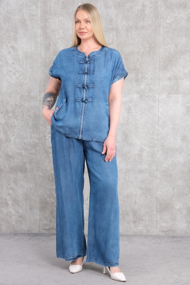  Продукт, который вы видите на модели, это спортивный костюм для женщин больших размеров синего цвета. Верхняя часть костюма обеспечивает комфортный и стильный вид. Она особенно примечательна короткими рукавами и деталями в виде пуговиц на передней части. Нижняя часть представлена широкими брюками. Состав ткани — 100% хлопок, что обеспечивает высокий комфорт и воздухопроницаемость для пользователя. Доступные размеры: 42, 44, 46 и 48.